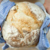 Brot in Geschirrtuch wird von zwei Hängen übergeben
