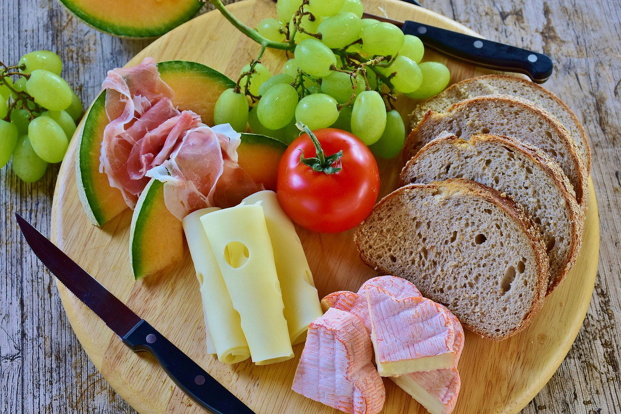 Holzbrett mit Brot, Wurst und Käse